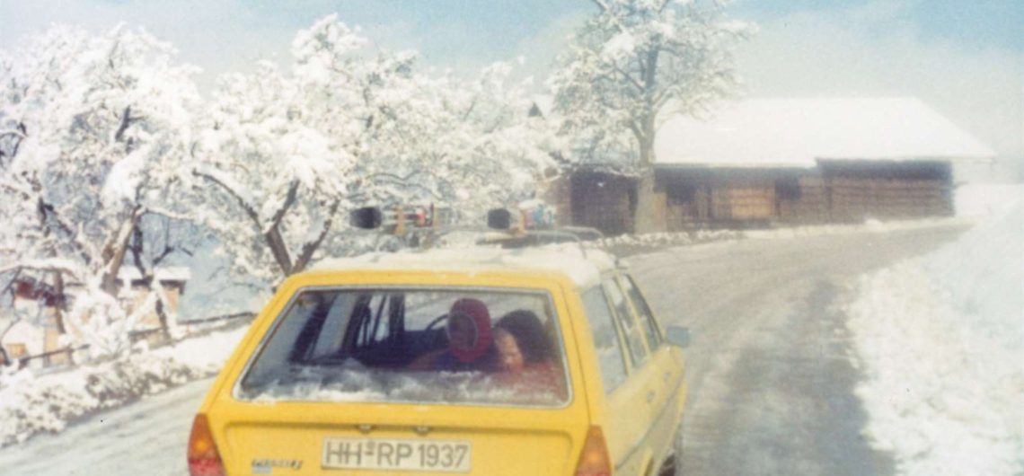 reise durch europa - Gelbes Auto auf einer verschneiten Straße.