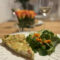 Quiche Lorraine - Ein sStück Quiche mit Salat und einem Glas Wein.